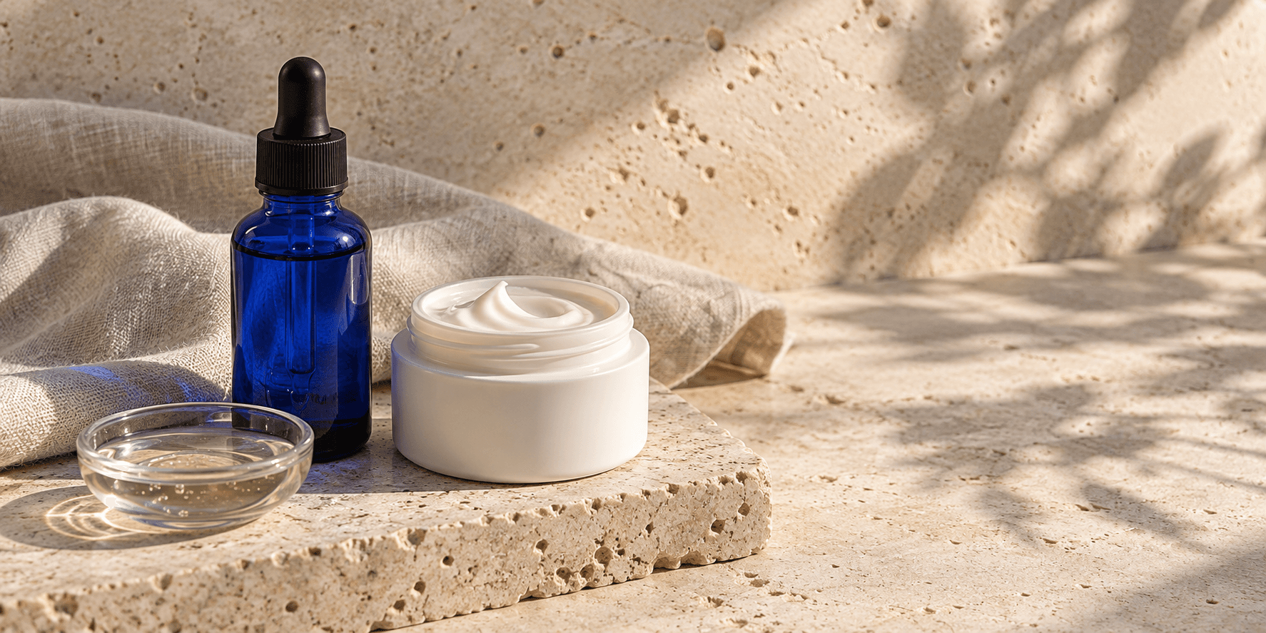 Unbranded serum and moisturizer on pale stone